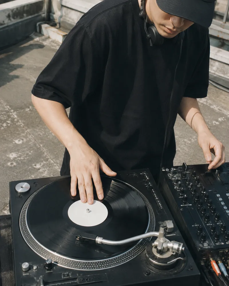 屋上でターンテーブルを操作するDJ