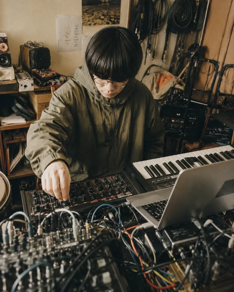 機材に囲まれてシンセを操作するエレクトロ作家