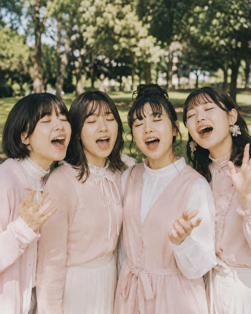 公園で肩を寄せて合唱する4人組アカペラ